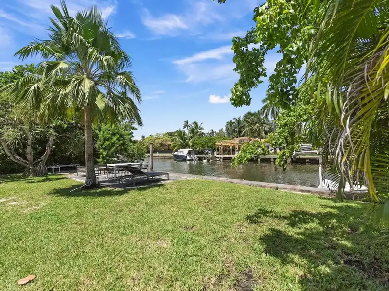 Waterfront backyard lawn with palm trees